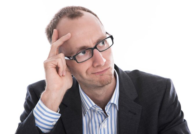 24142445 - skeptical manager in a suit, shirt and glasses - isolated on white